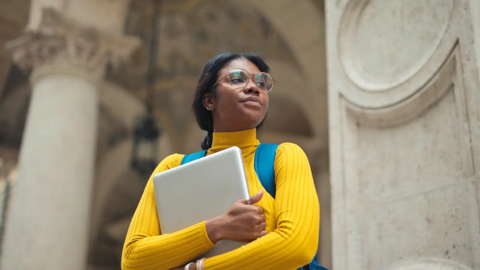 Which Scholarships Are Available to African Students? African student holding a passport and backpack, smiling at an international university campus