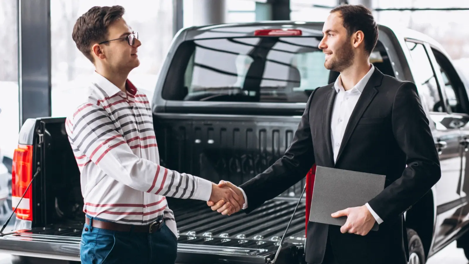 The Best Deals for No Money Down Car Financing in 2025 Car buyer shaking hands with dealer after securing a no money down auto loan
