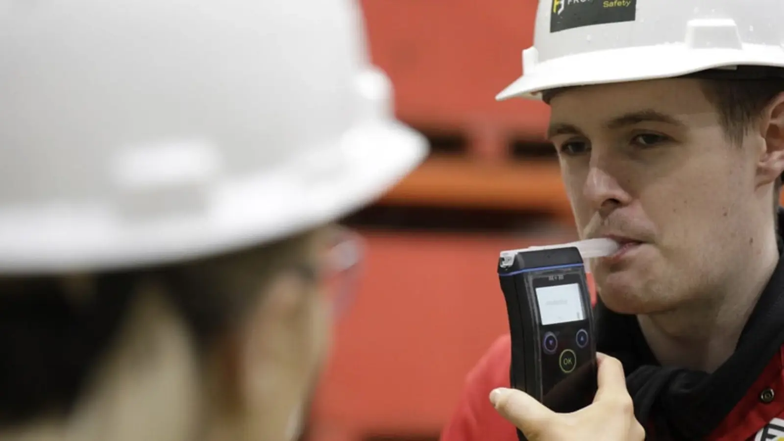 Employee using a workplace breathalyser for safety and compliance testing