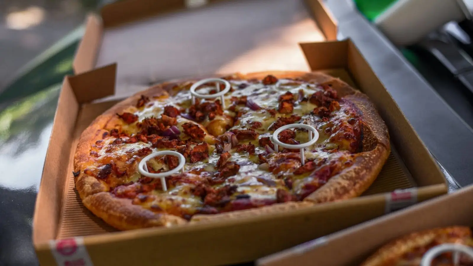 Freshly baked pizza in a branded box at a profitable pizzeria