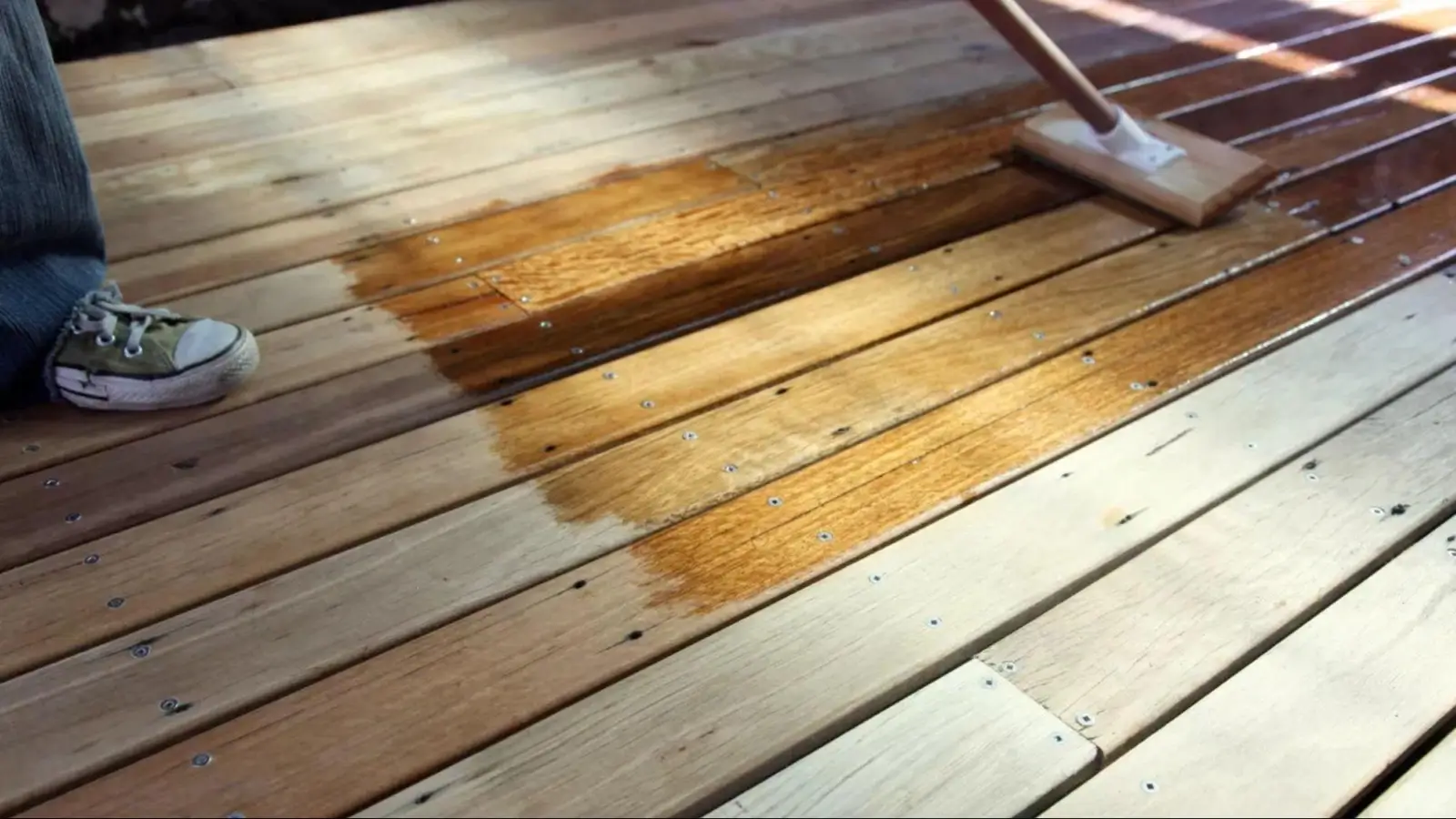Freshly stained wooden outdoor deck with natural wood grain and garden seating