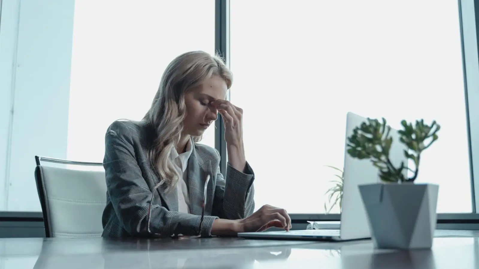 Frustrated business owner looking at frozen computer while waiting for IT support