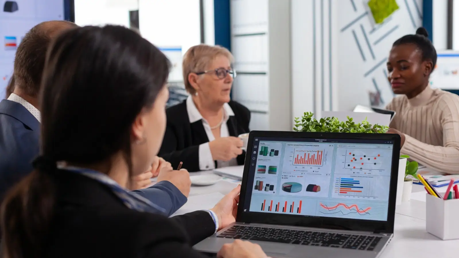 Managed Service Provider team working on digital strategy with data charts and laptops