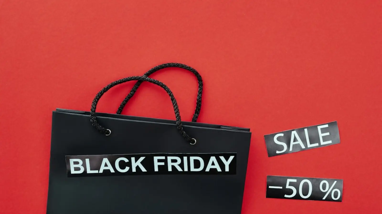 Black Friday 2025 : What’s Changing & What to Expect Shoppers browsing Black Friday deals on smartphones and laptops in a modern retail setting