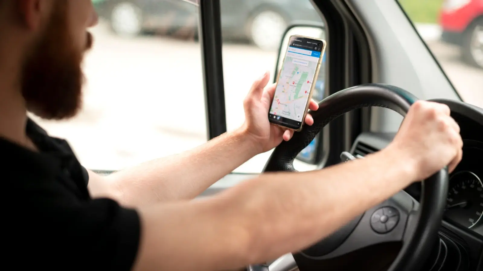 Small business owner using a mobile mileage tracker app in a car