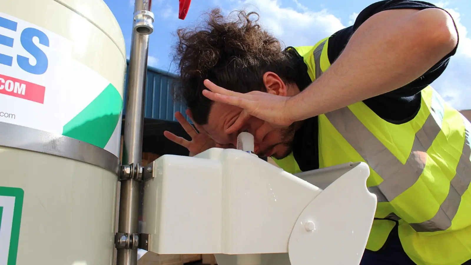 How Businesses Can Ensure Rapid Responses to Chemical Emergencies Worker using emergency eyewash station during chemical spill in industrial workplace