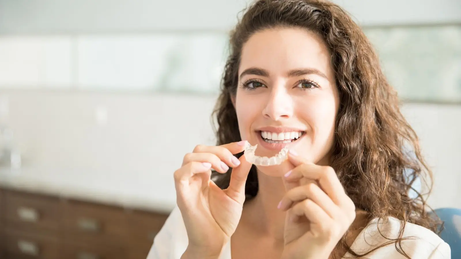 Adult smiling with Invisalign clear aligners during orthodontic treatment