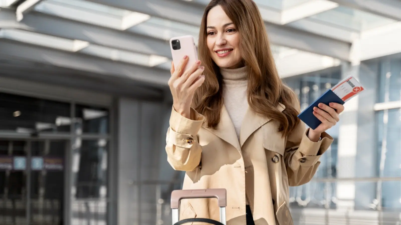 Business traveler navigating airport with luggage and mobile boarding pass