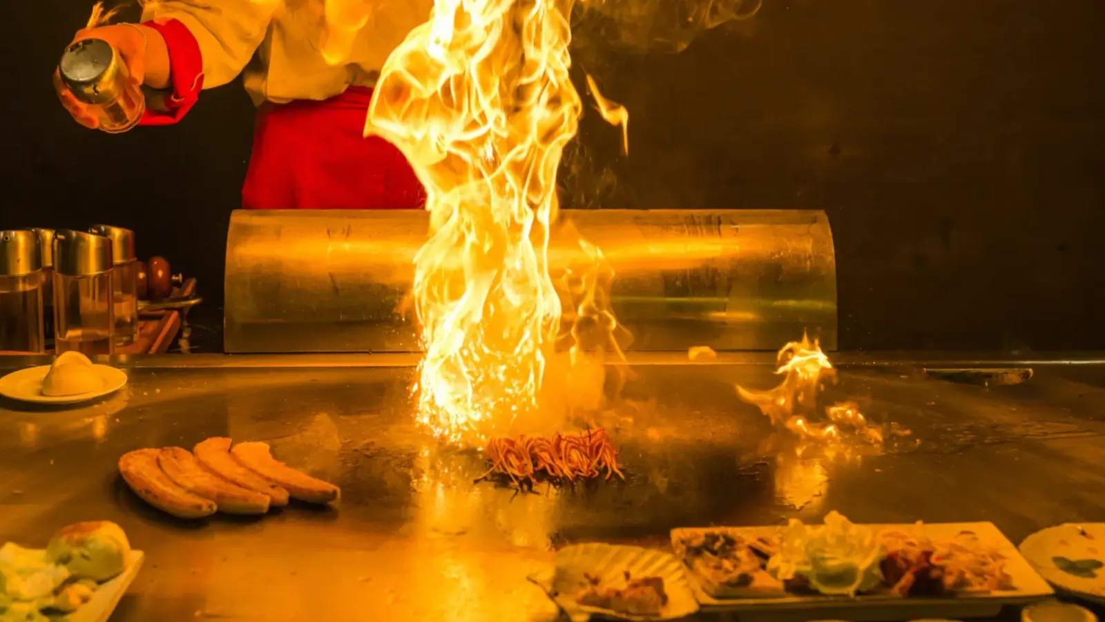 Chef cooking teppanyaki on an iron grill in a hotel restaurant in Osaka