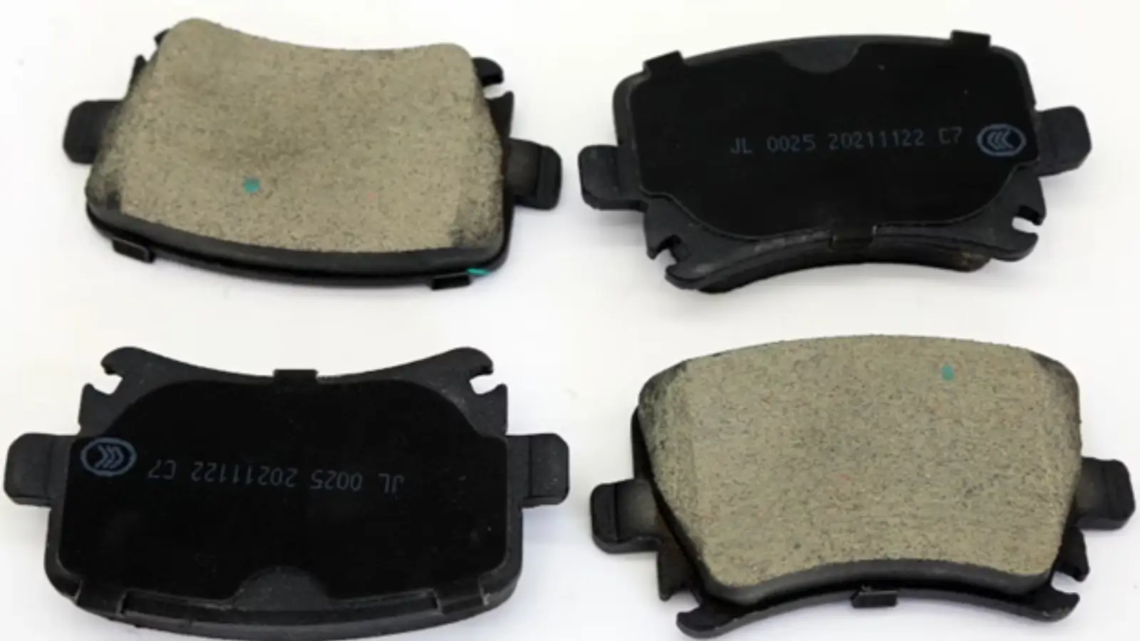 Close-up of Jinli brake pads installed on a car wheel with clean rotors