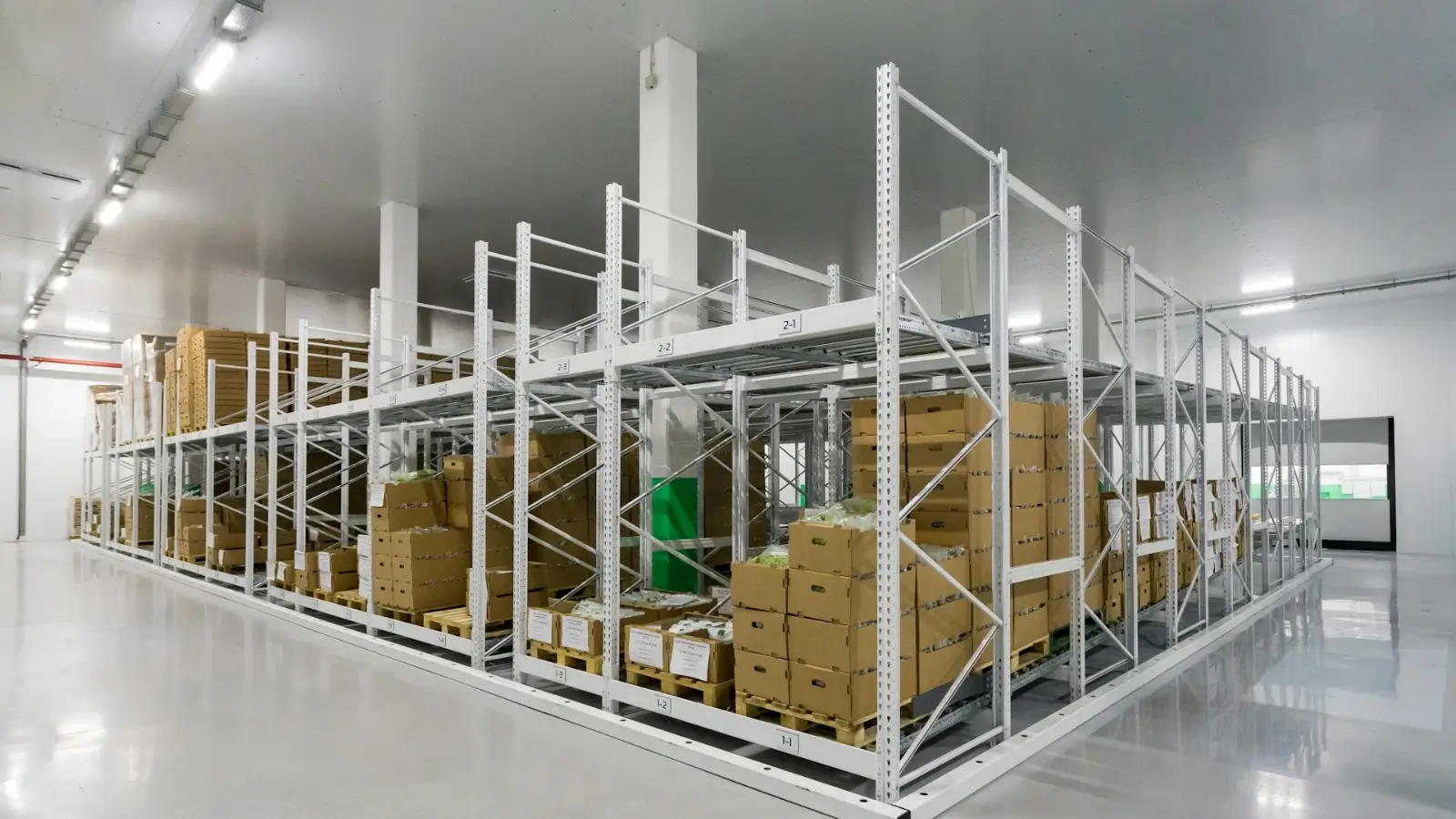Collapsible stillage units stacked in a warehouse for efficient logistics operations