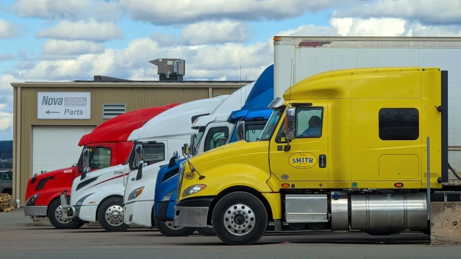 Commercial trucks parked securely at Mr. Parker Hollywood truck parking facility near a construction site
