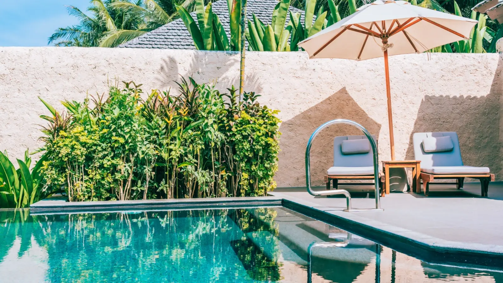 Custom pool design in a corner lot with landscaping and privacy features