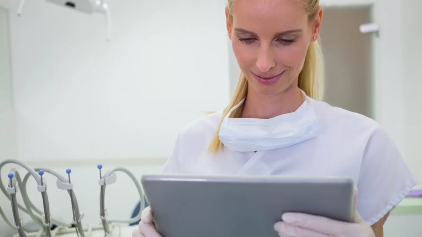 Dentist checking local SEO performance on a tablet with dental tools in background