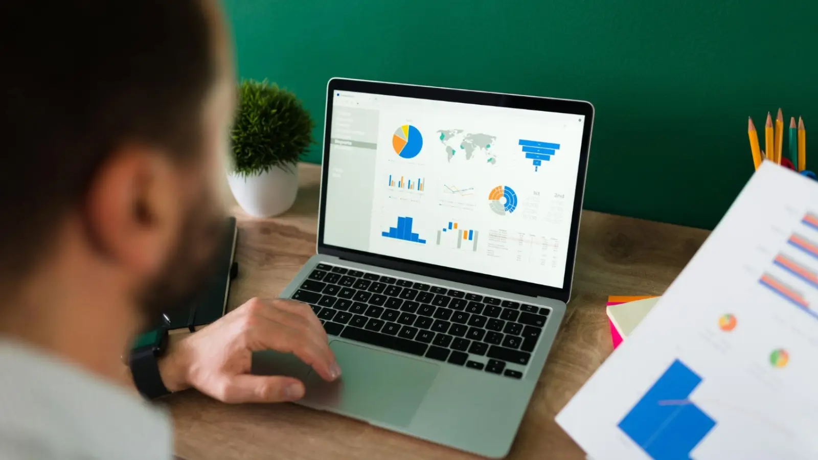 Digital marketer analyzing online performance trends on a laptop with charts and graphs