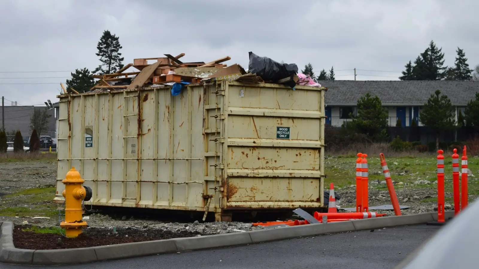 Dumpster rental and removal tech crew loading debris from a residential renovation site