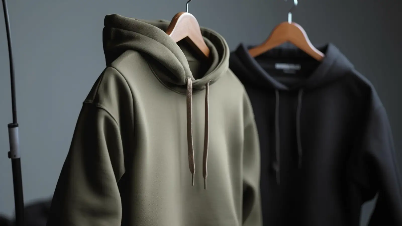 Fear of God Essentials hoodie in neutral tone displayed on hanger with minimalist background