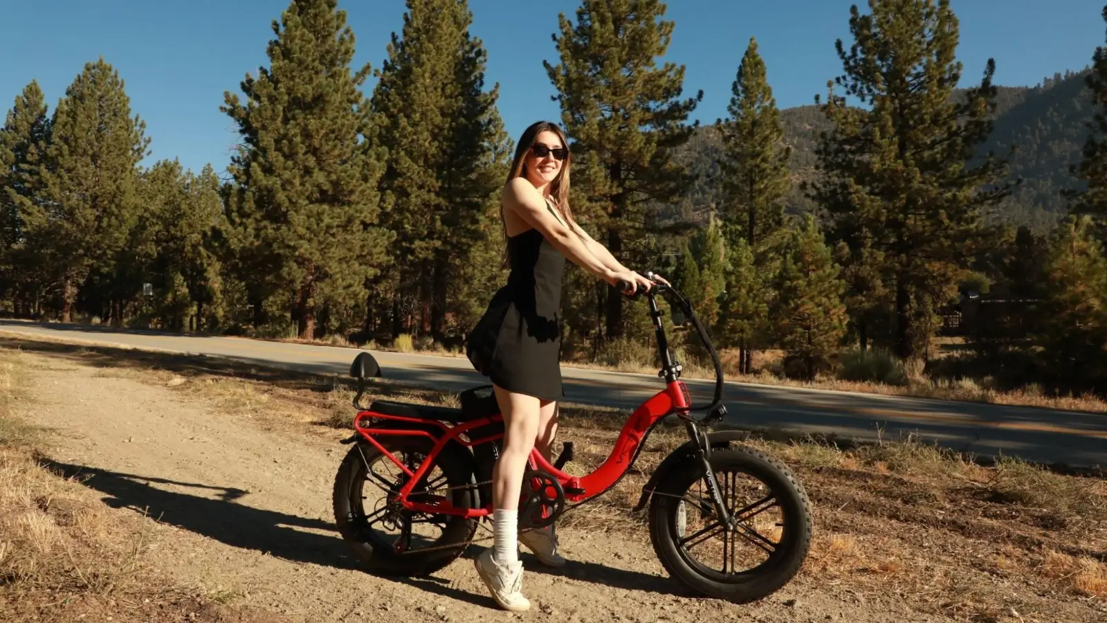 Folding fat tire electric bike parked beside an RV on a campsite trail