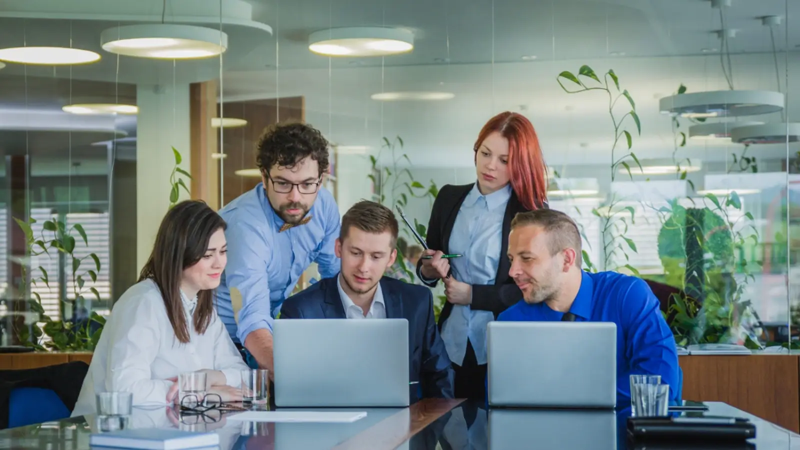 Industrial marketing team planning manufacturing lead generation strategy on laptop