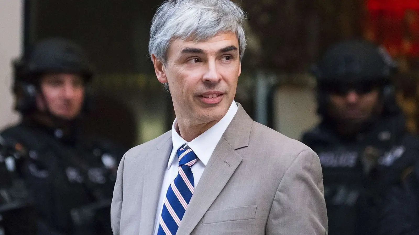 Larry Page with Alphabet logo and stock market chart in background