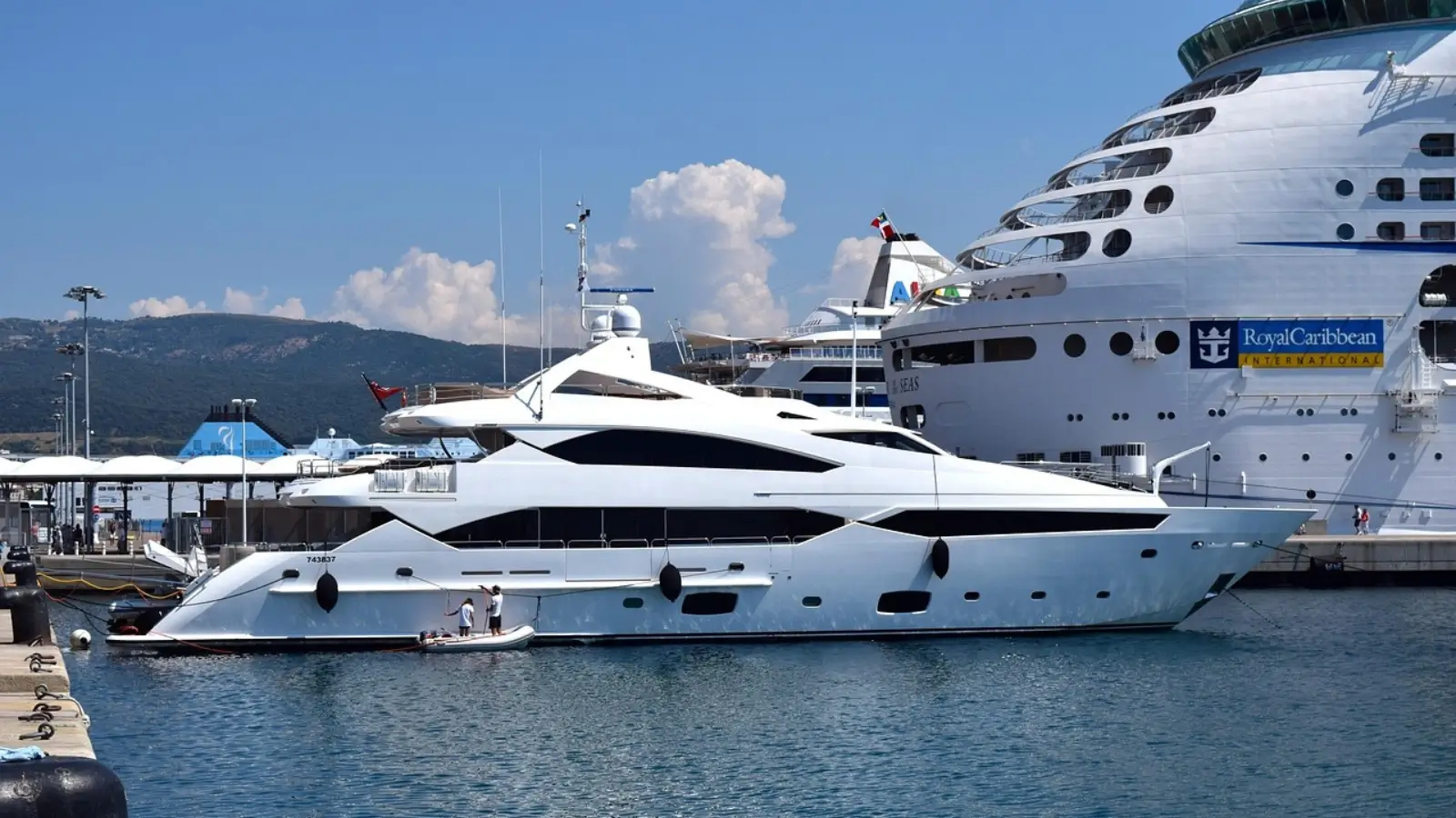 Luxury yachts docked at an international boat show with visitors exploring the decks