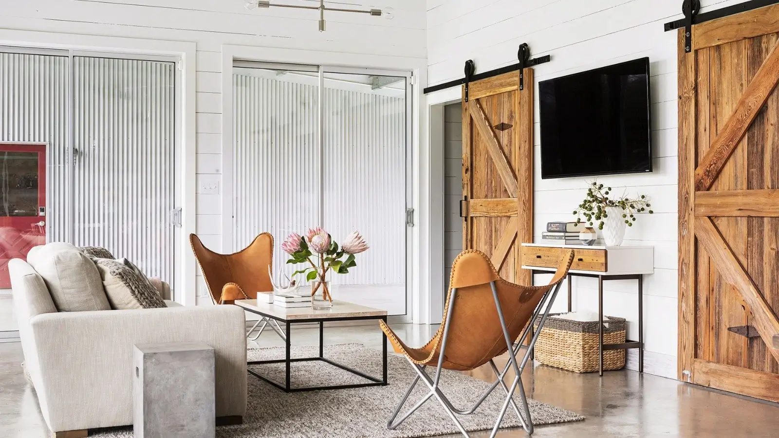 Modern living room featuring a sliding door with hidden barn door hardware
