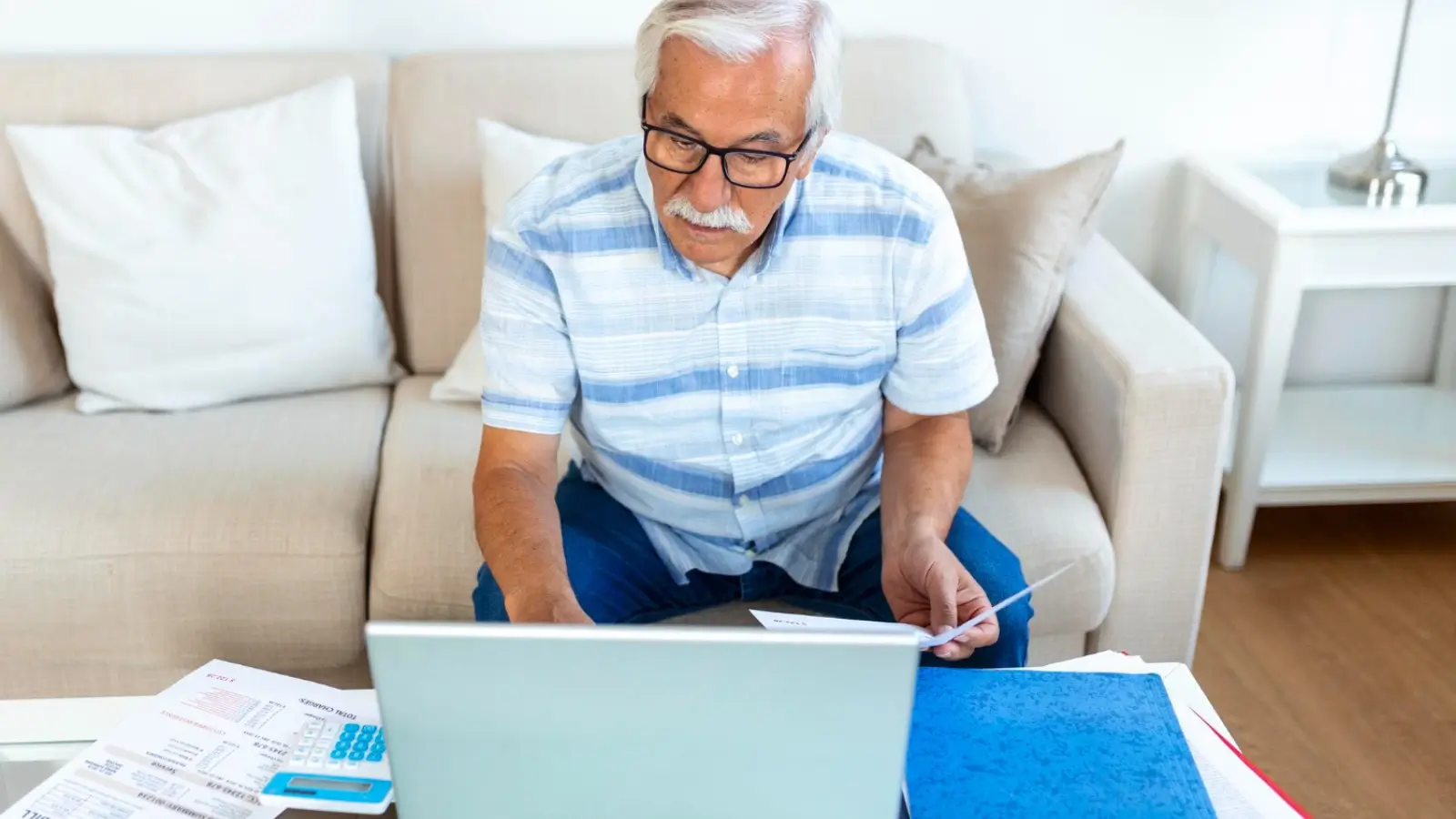 Person reviewing pension savings documents with calculator and notepad