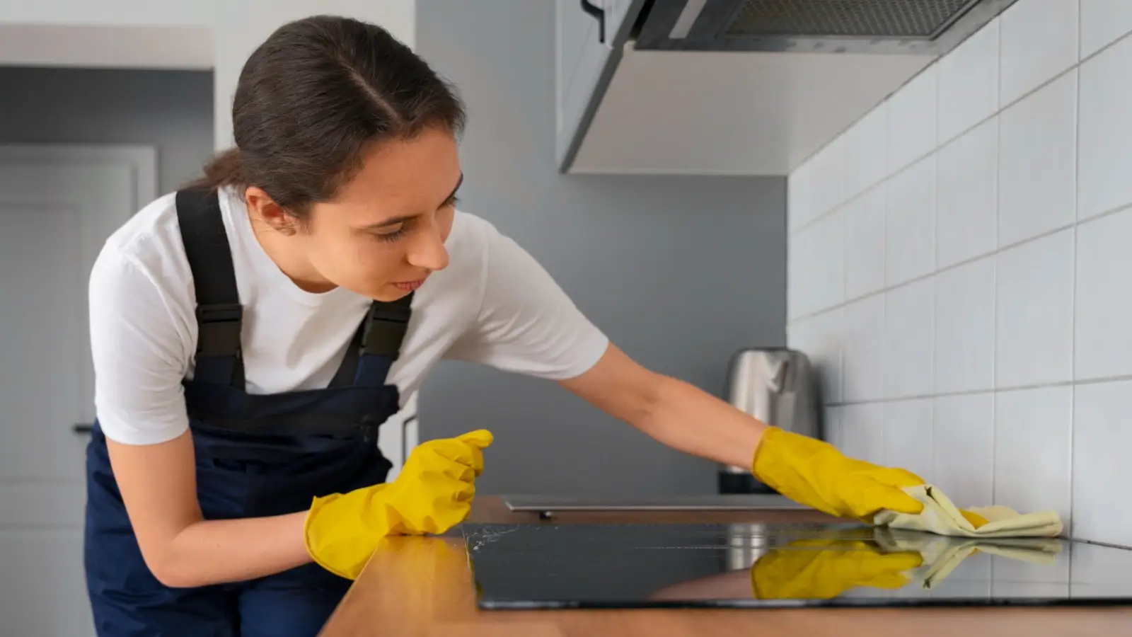 Professional house cleaner wiping down kitchen counter in a modern home