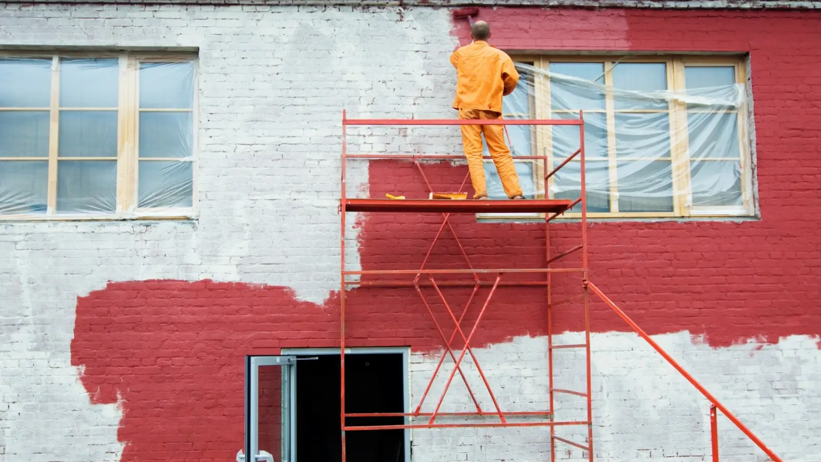 Professional painters working on a commercial building exterior with scaffolding