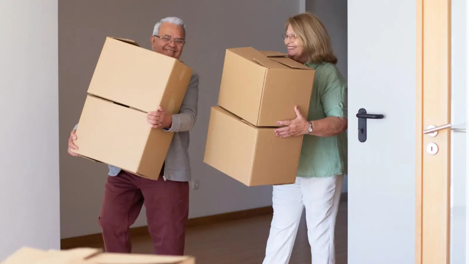 Senior couple packing boxes while downsizing to a smaller home