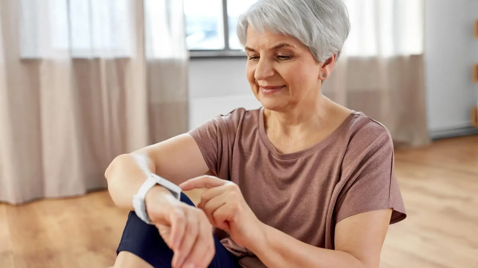 Senior woman using smart home technology in a well-lit, accessible living space