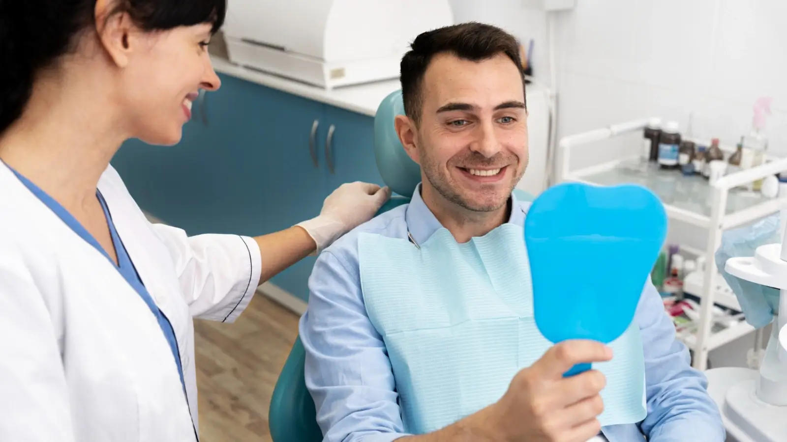 Smiling patient receiving dental consultation for implants and restorations