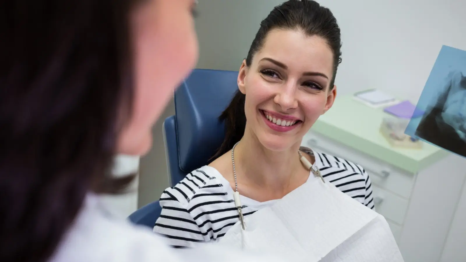 Smiling patient with natural-looking porcelain veneers after dental treatment
