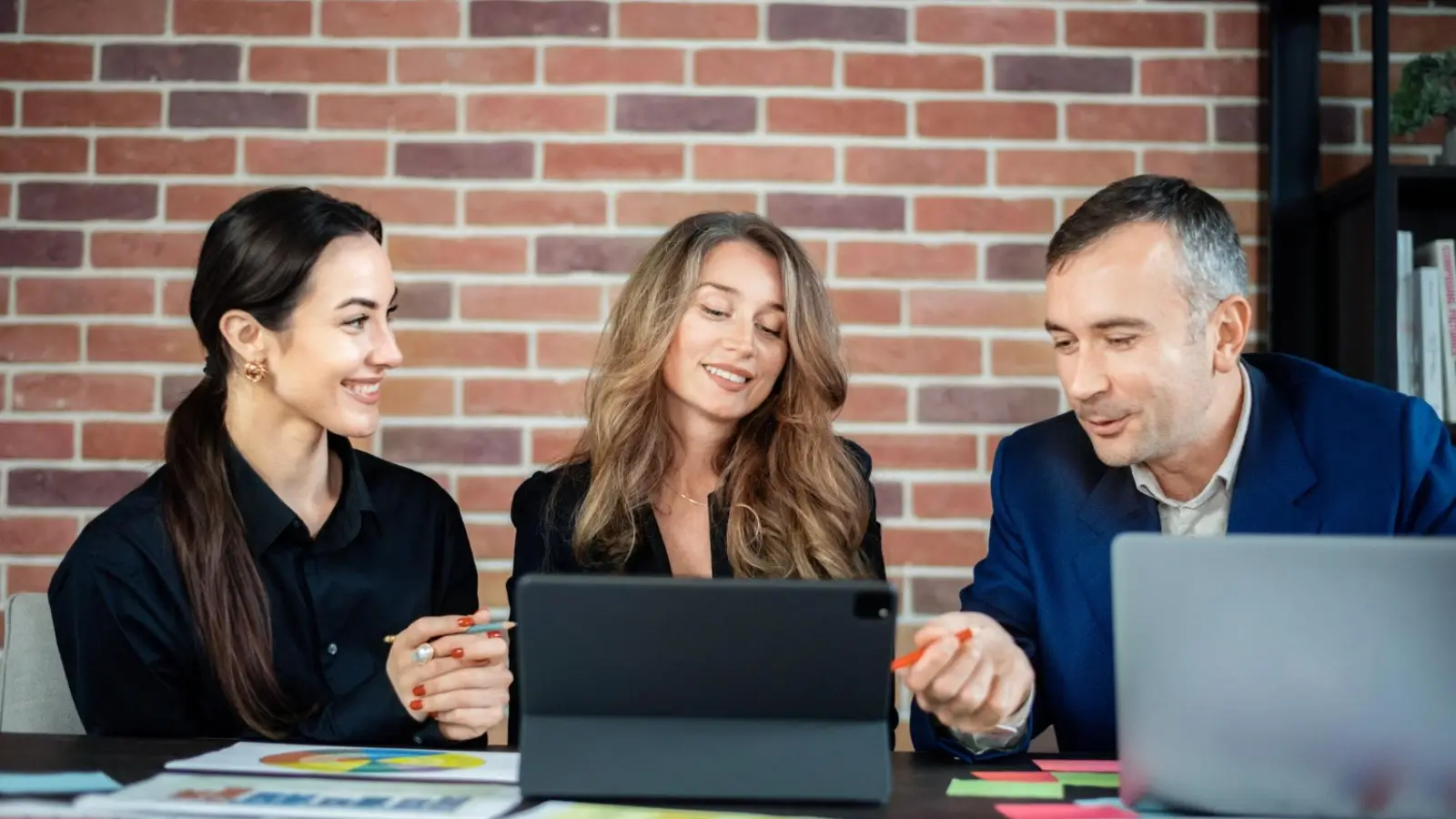 Team of digital marketers managing a Google Ads campaign on laptop screens