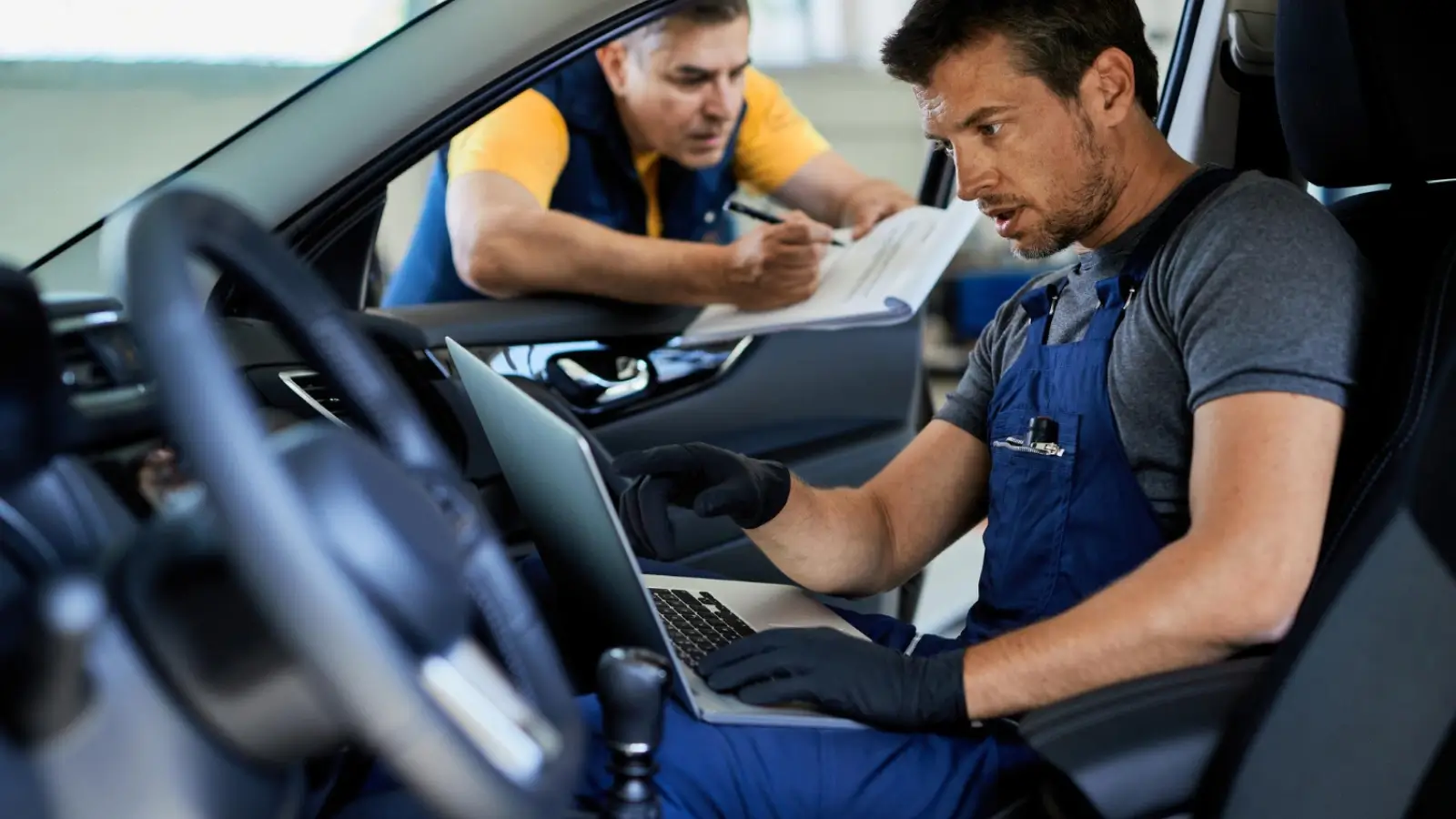 Technician checking car AC system at a used car dealership in Wichita Falls