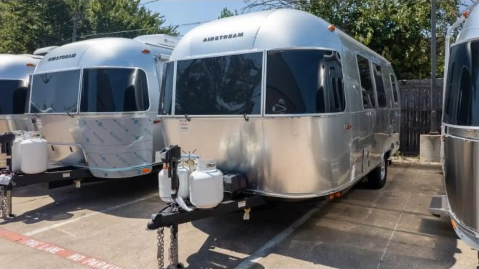 Three Airstream trailers—Bambi, Caravel, and Basecamp—parked side by side in scenic outdoor location