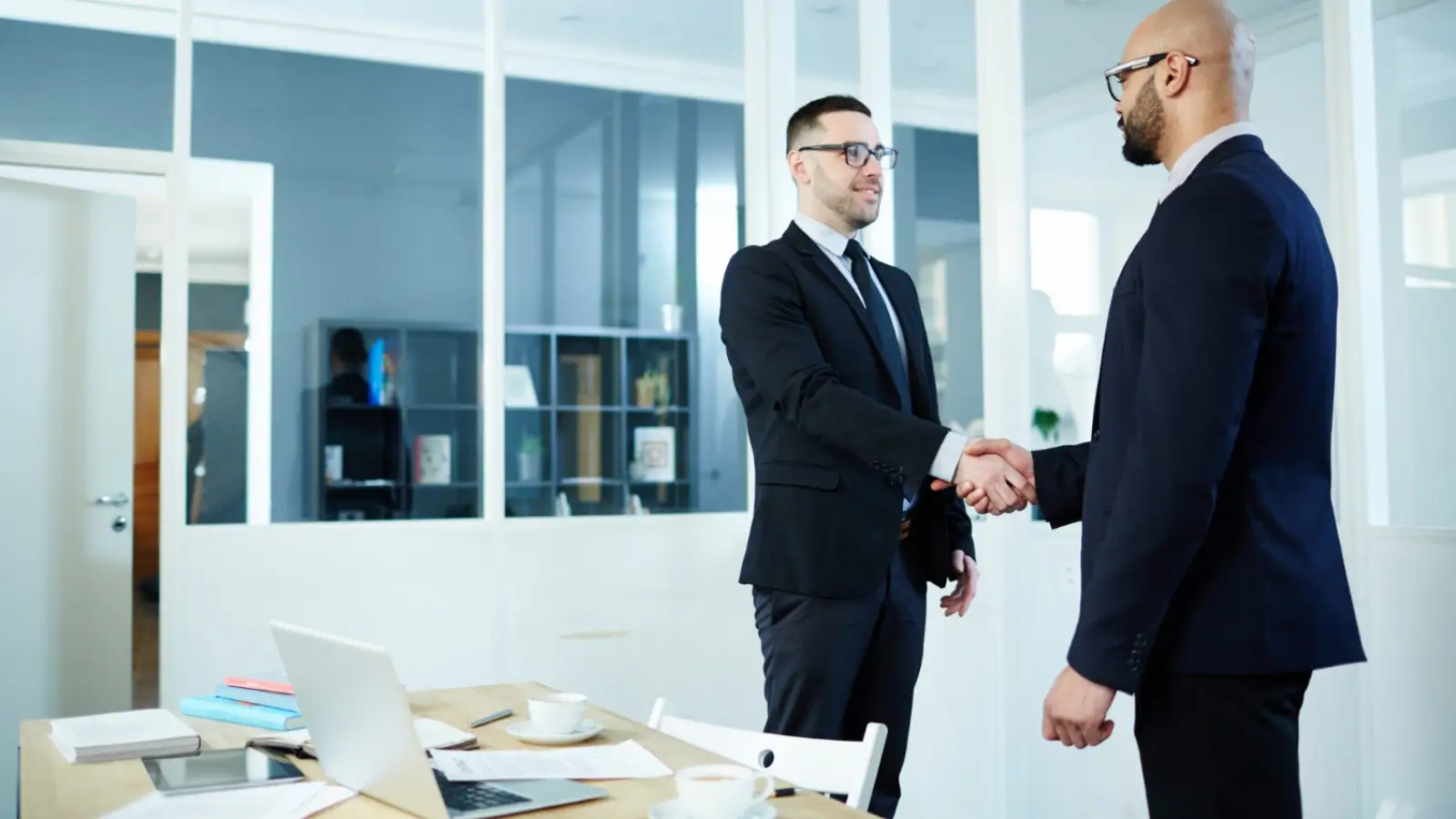 Two business professionals shaking hands after signing a long-term collaboration contract