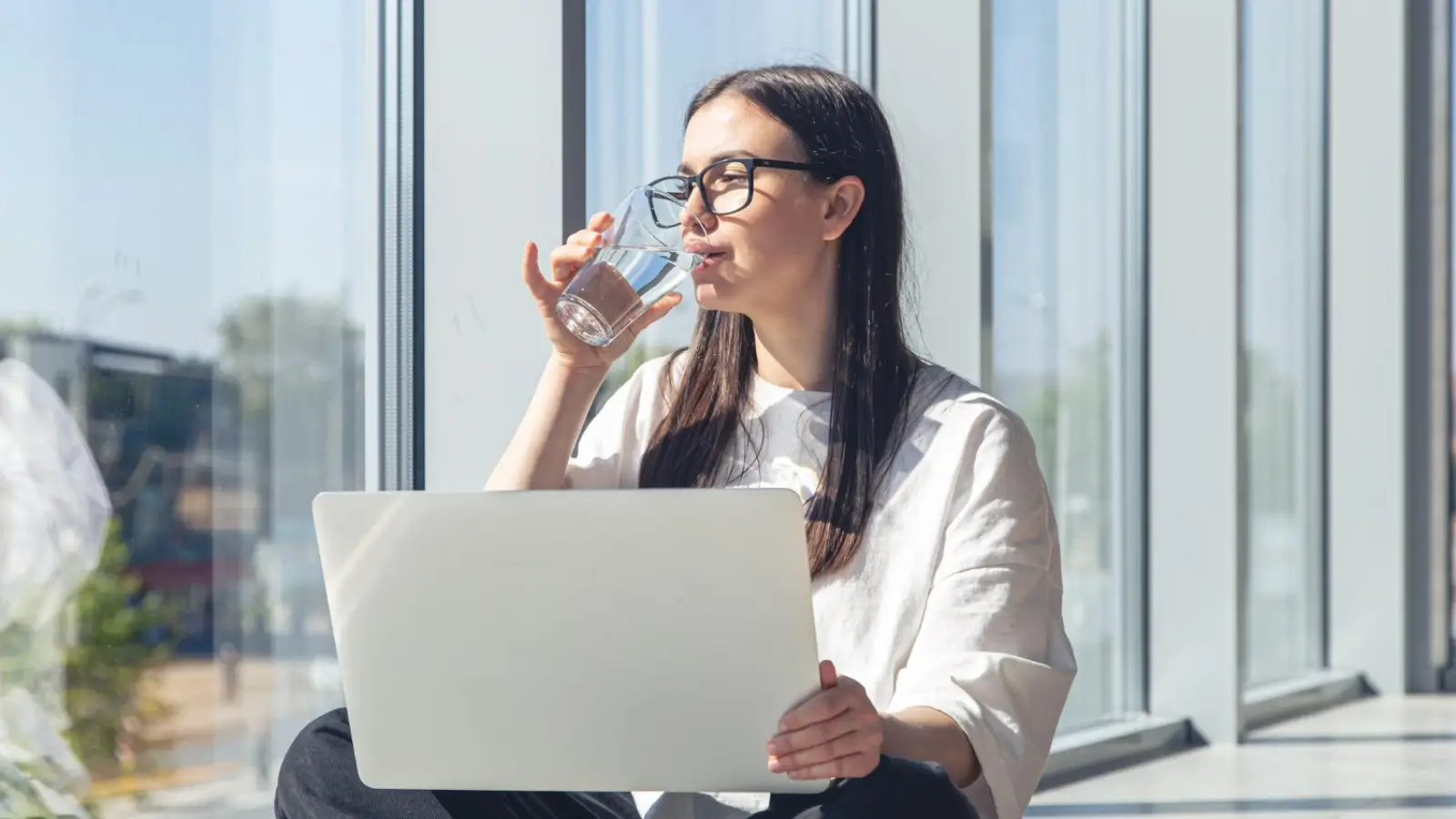 Woman enjoying a mindful break with a water bottle at her desk