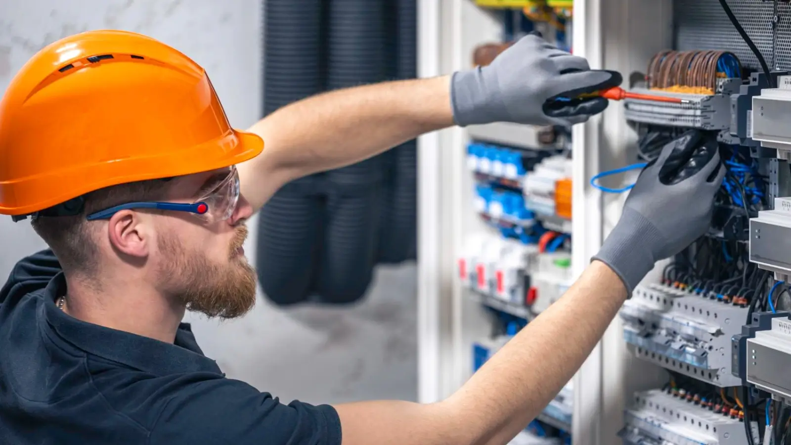 Commercial electrician working on a modern electrical panel with smart wiring