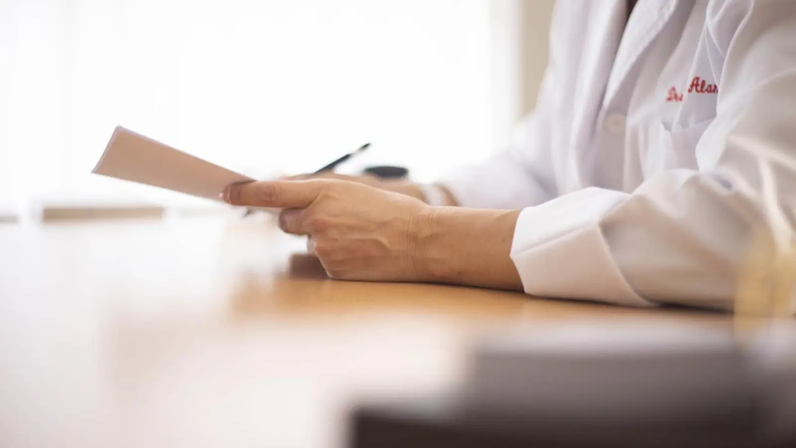 Doctor reviewing financial reports with a team in a medical office setting