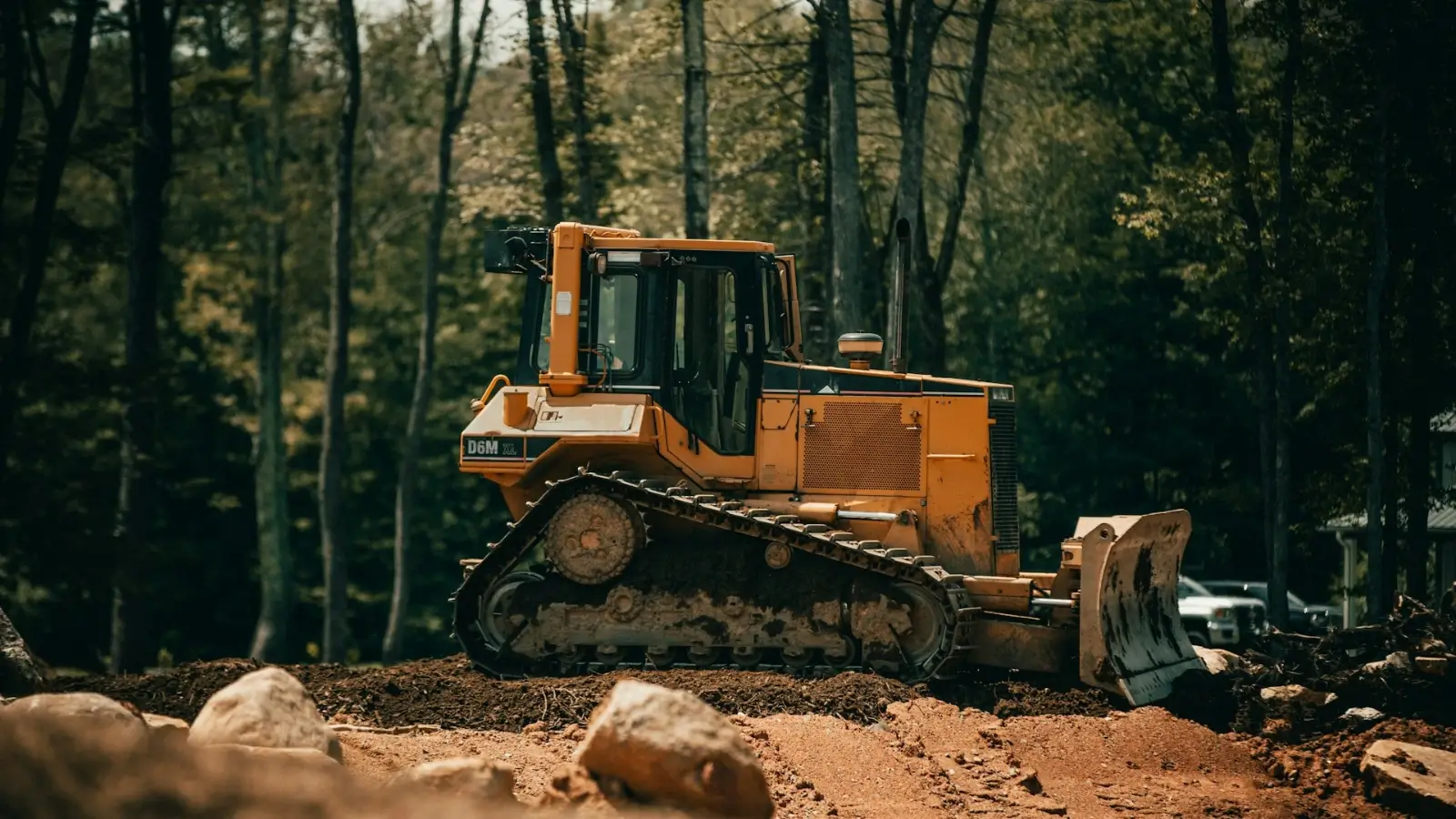 Excavator clearing trees and brush on a construction site during land preparation