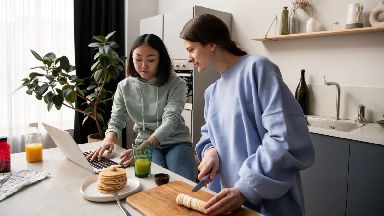 Roommates reviewing cleaning costs in a shared NYC apartment kitchen