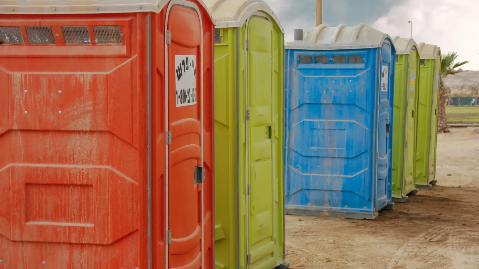 Row of clean portable toilets set up at an outdoor construction site