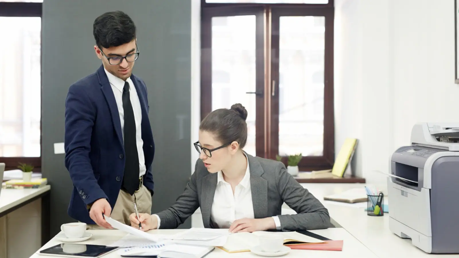 Sole trader reviewing tax documents with a professional accountant at a desk