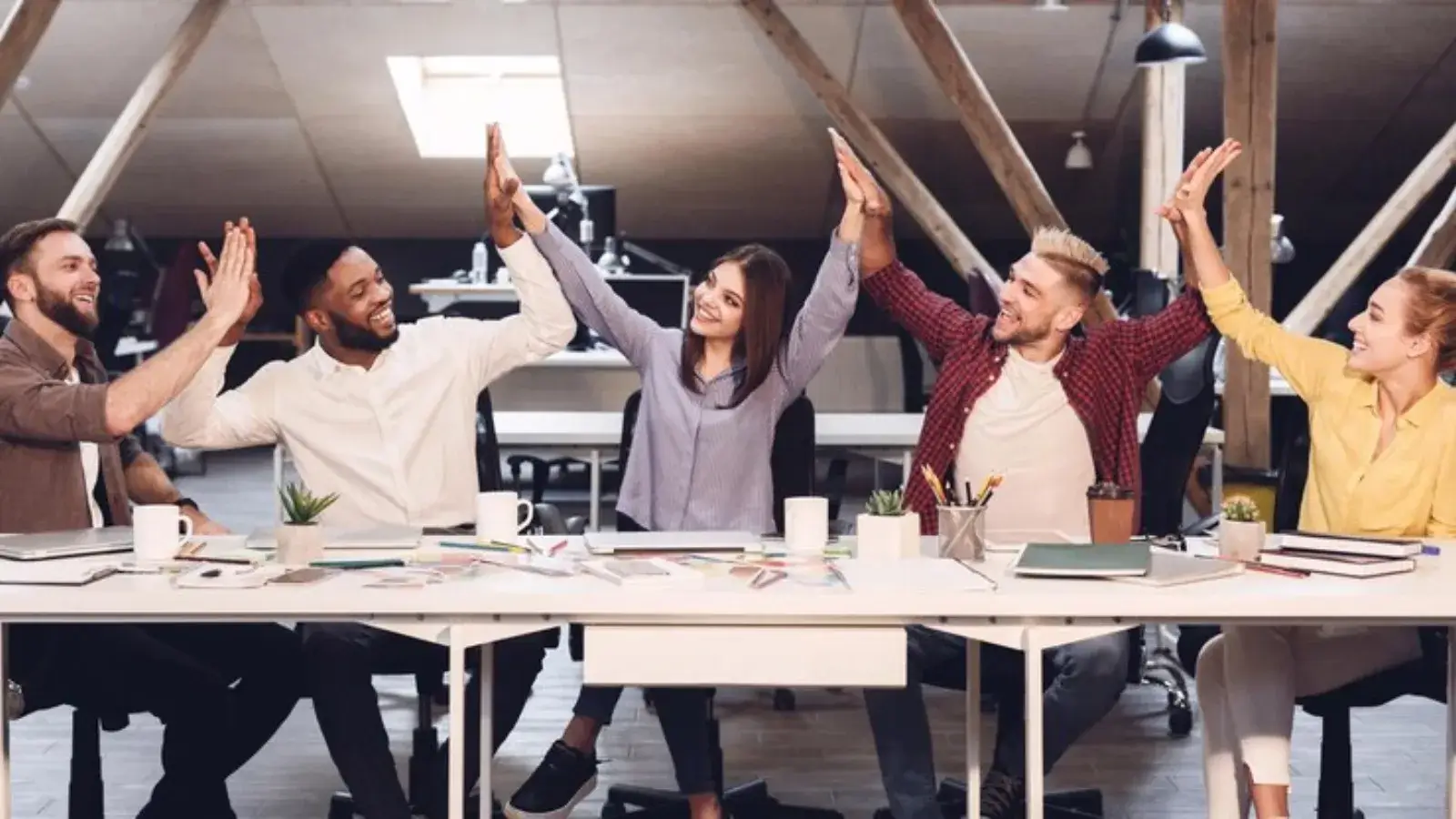 Creative Ways to Build Team Spirit in the Workplace Diverse team of coworkers smiling and collaborating in a modern office