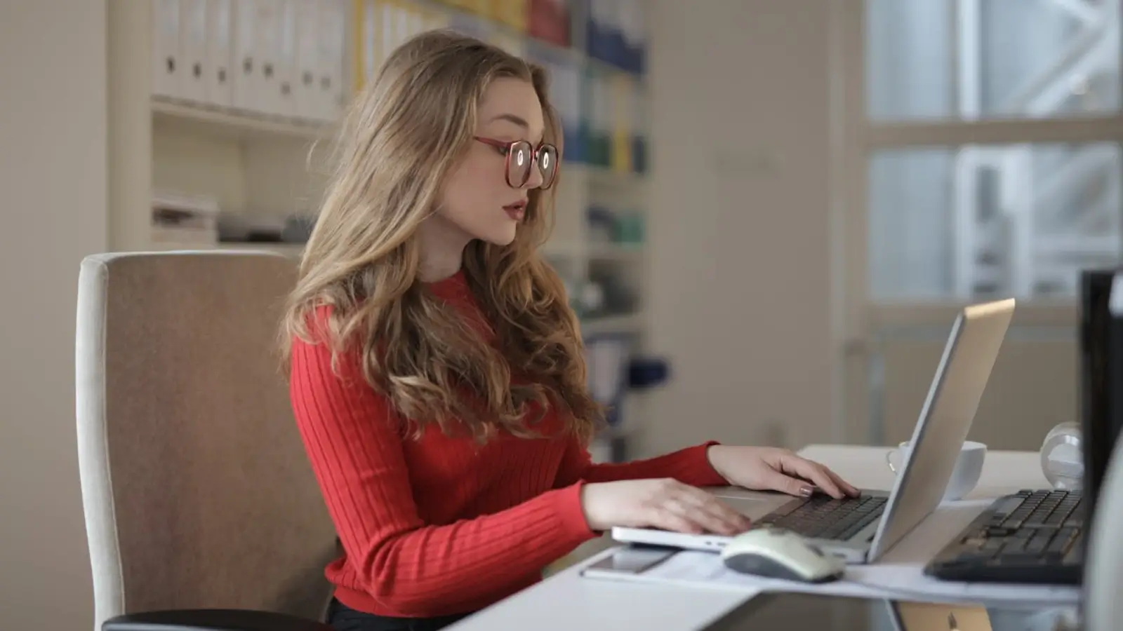 10 Tools Every Copywriting Business Needs Freelance copywriter working on laptop surrounded by productivity and writing tools