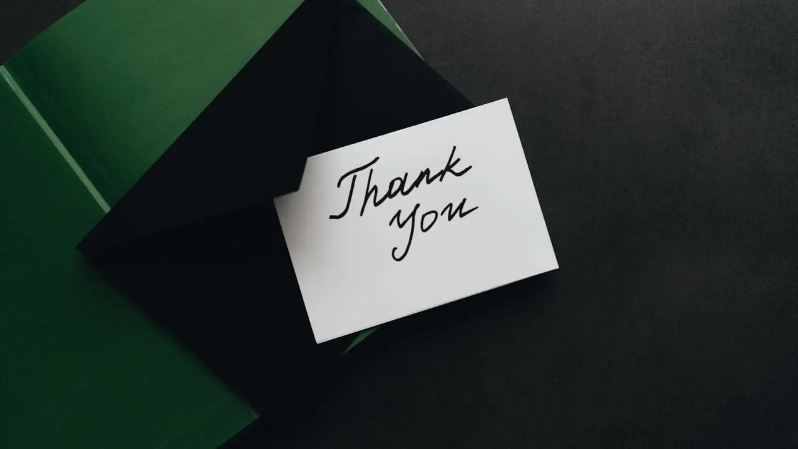 When Should You Send Thank You Cards in Business? Printed thank you cards on a desk with envelopes and business branding