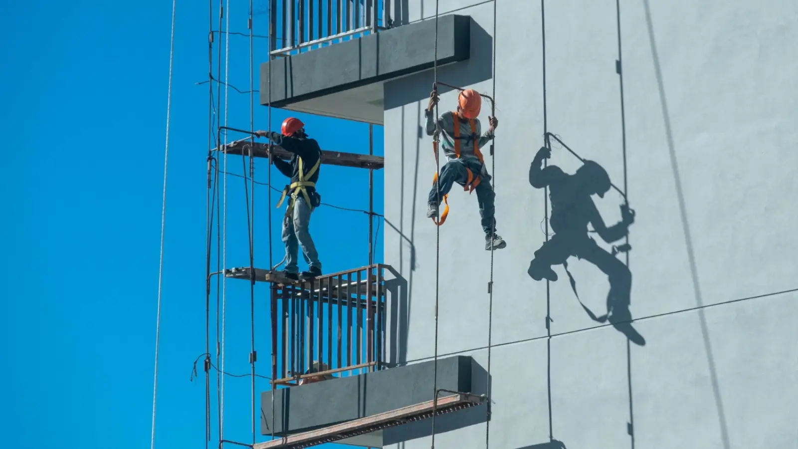Essential Safety Measures for Working at Heights Worker inspecting safety harness on a construction site at height