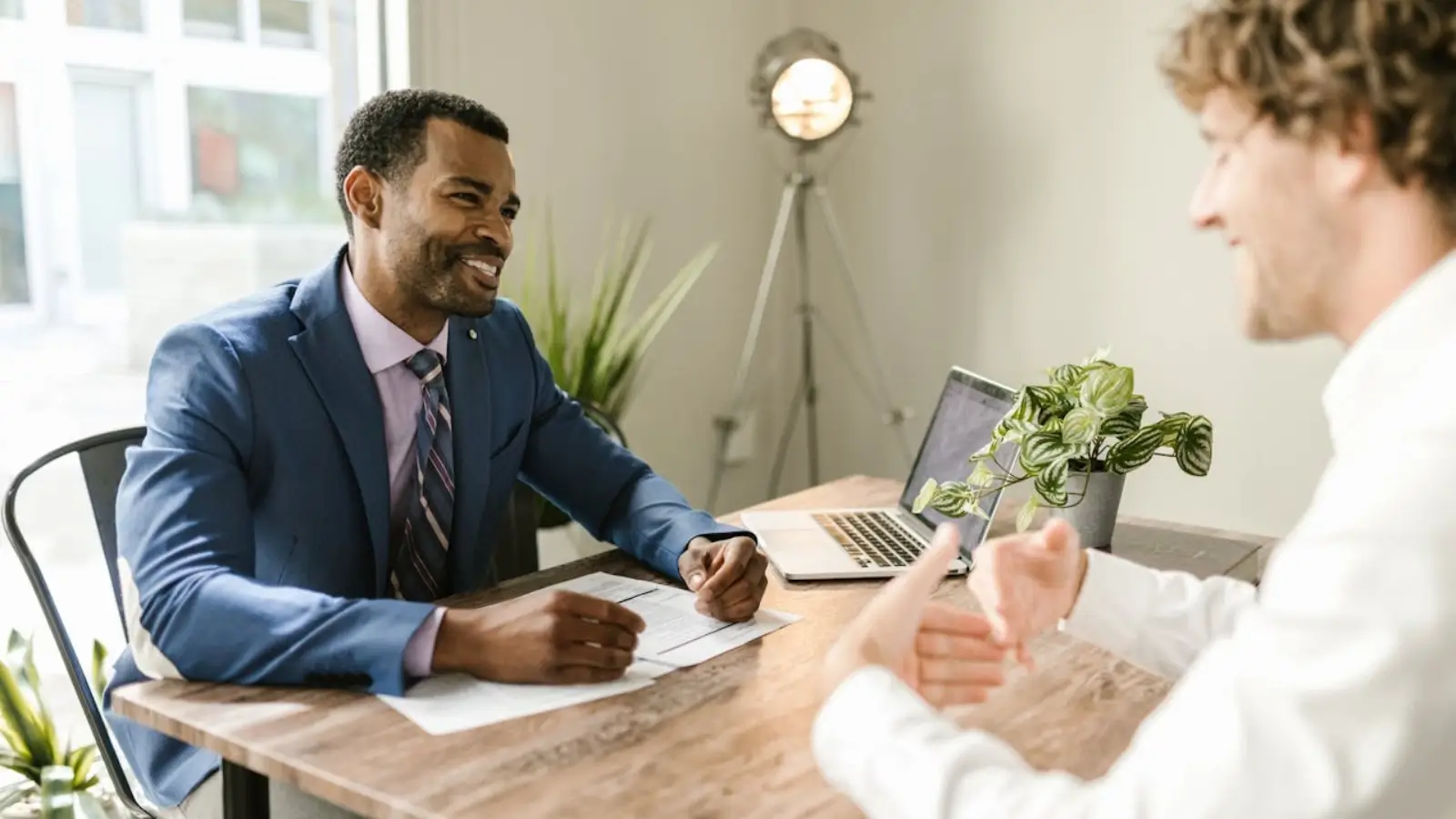 Financial advisor reviewing performance metrics and client portfolio reports with a client