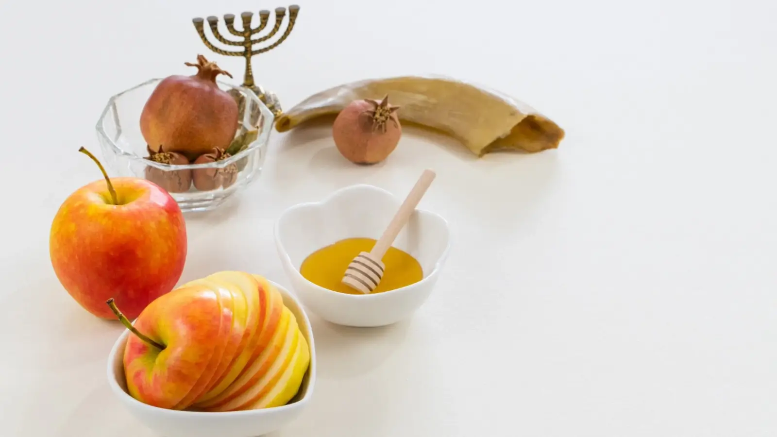 What Is Rosh Hashanah and How It’s Observed in 2025 Shofar being blown during Rosh Hashanah with apples and honey on a festive table